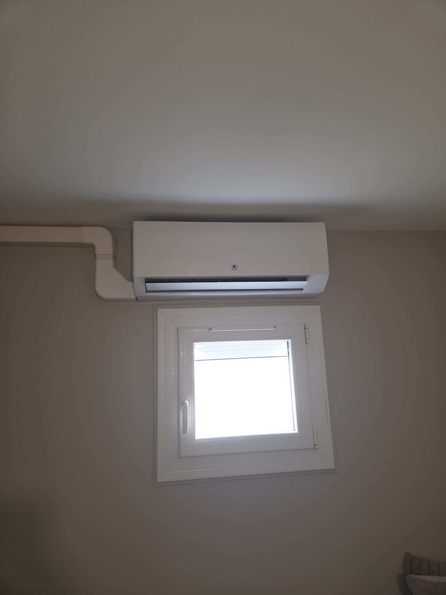Climatisation murale installée au-dessus d'une fenêtre