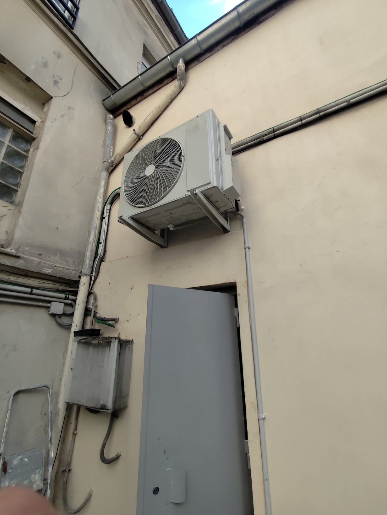 Unité extérieure de climatisation installée en cour parisienne